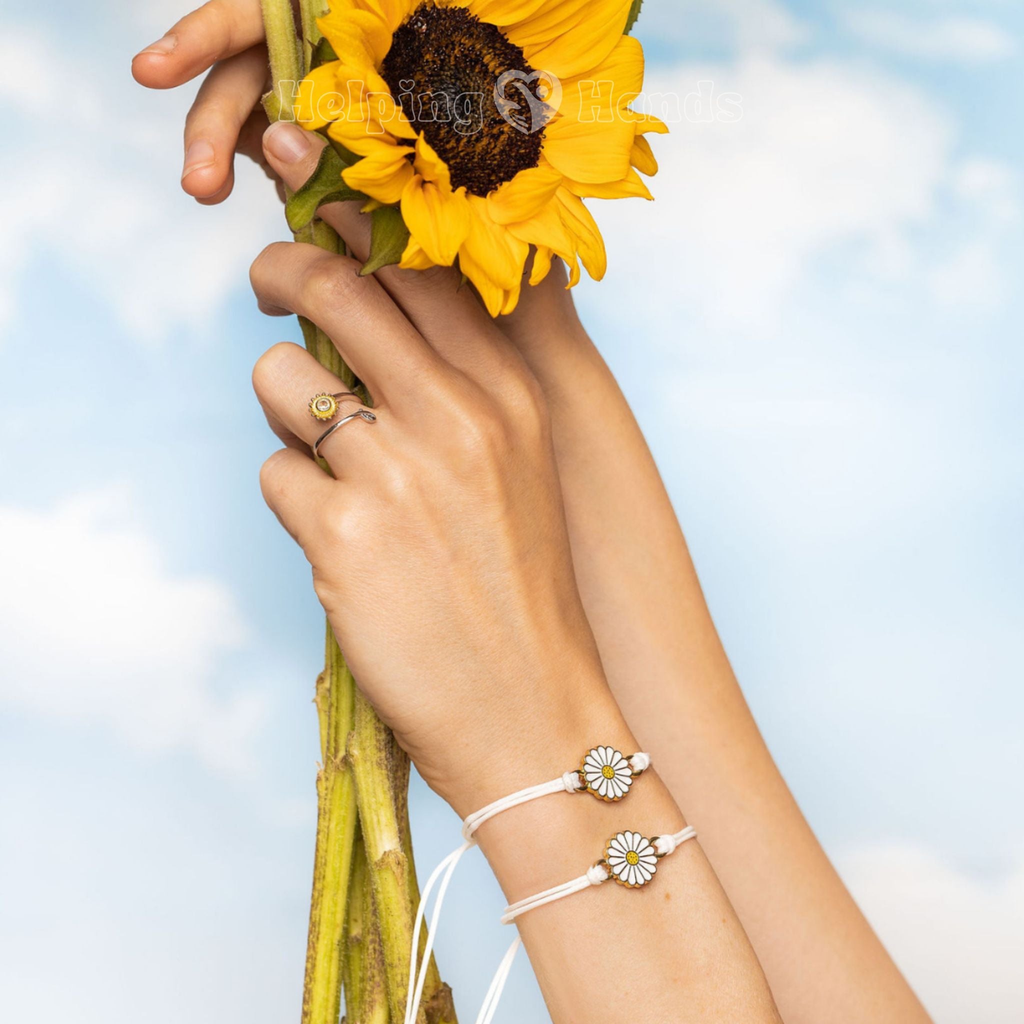 Person holding sunflowers with a clear blue sky background