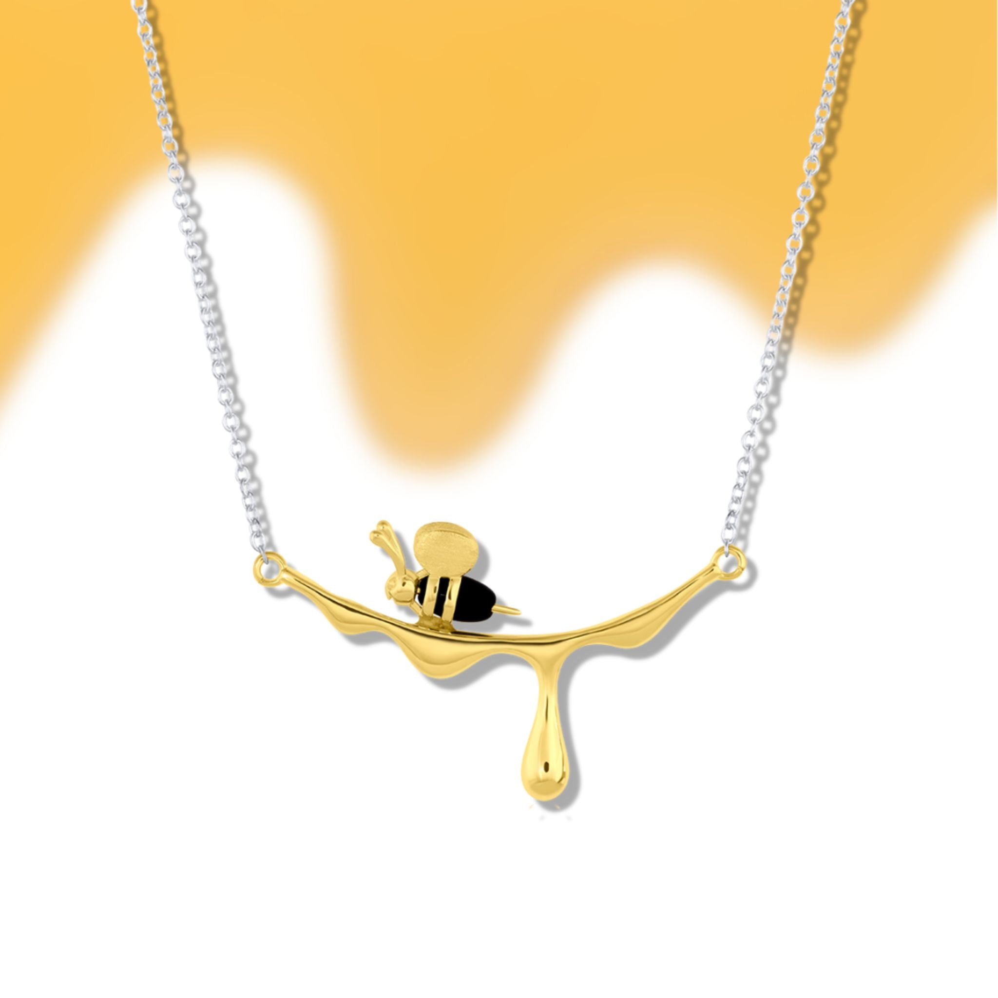 Necklace with a gold and silver bee pendant on a white background