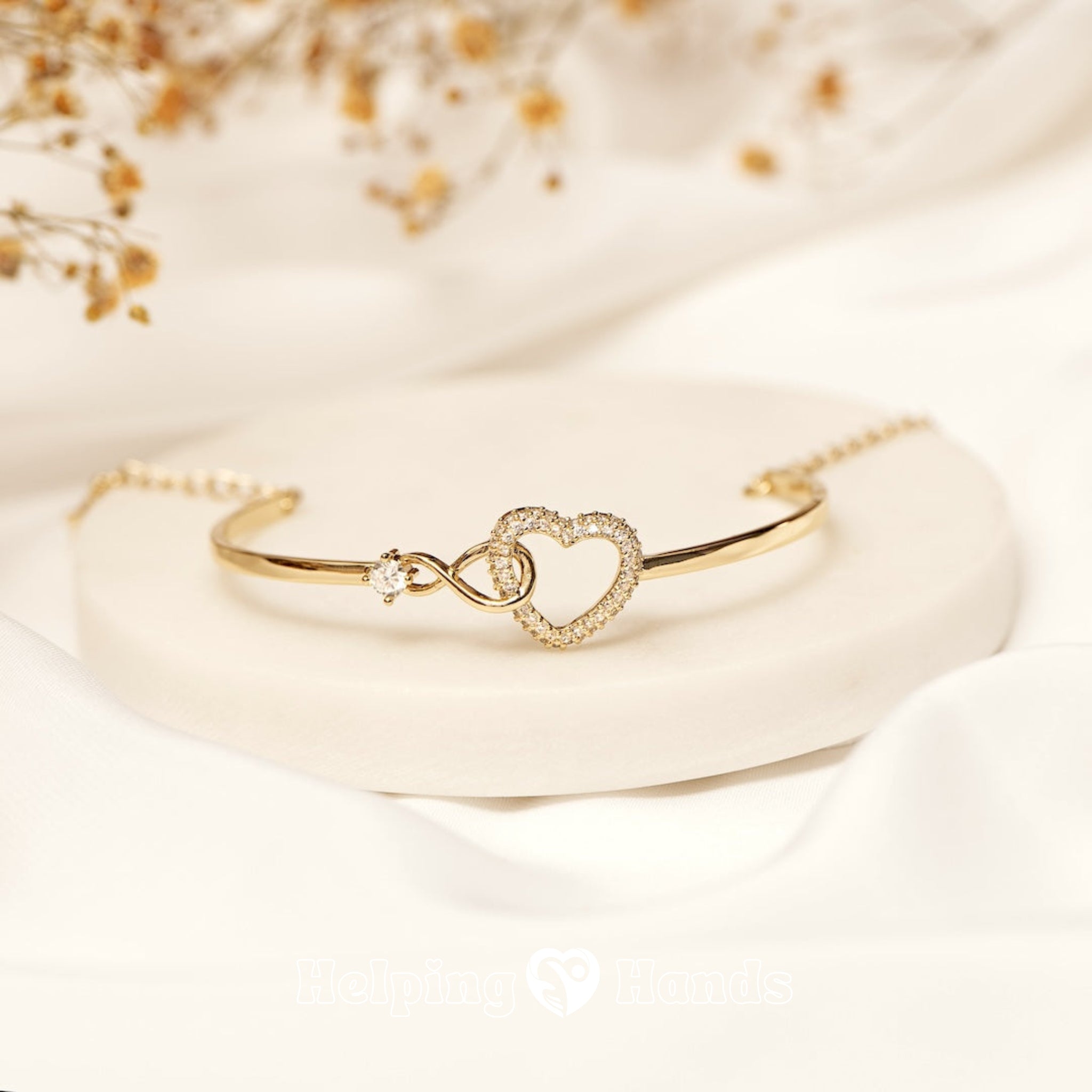 Gold heart bracelet with infinity symbol and single stone

