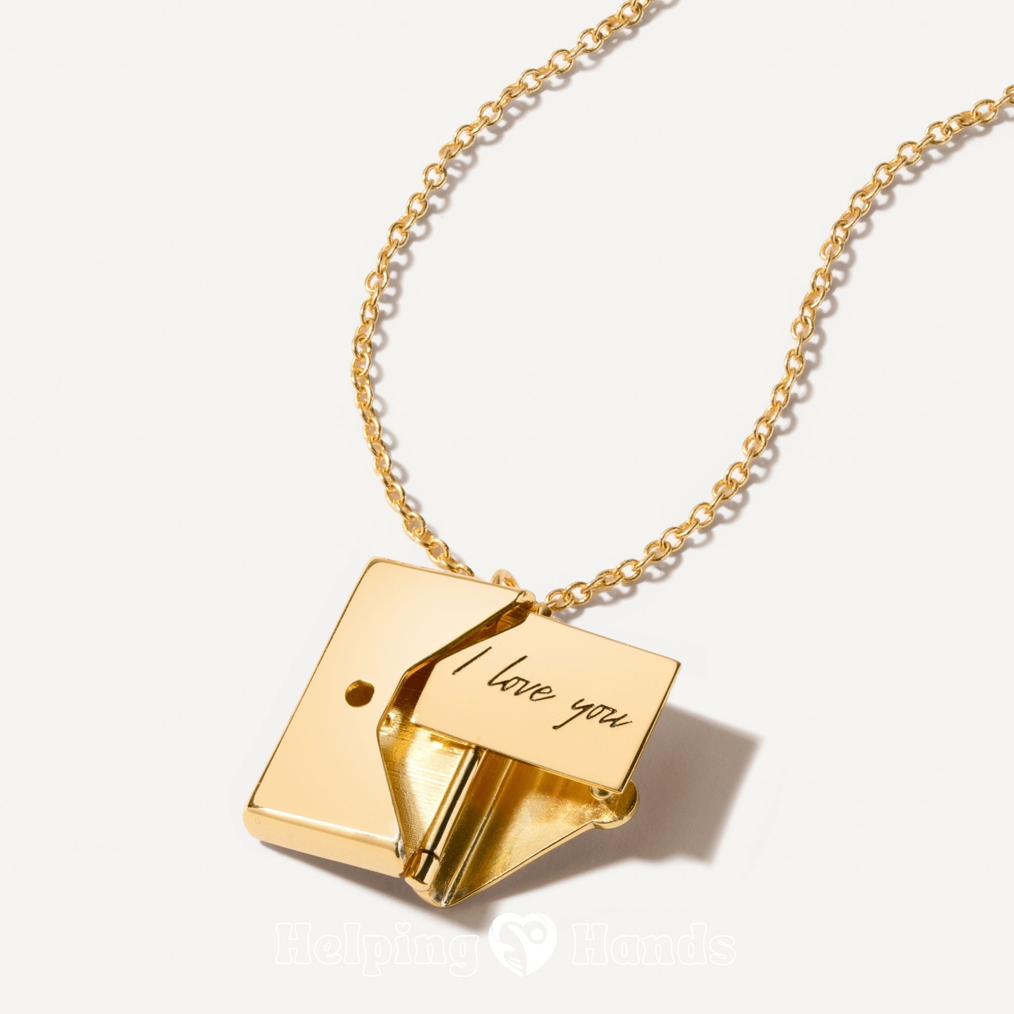 Gold necklace with a pendant that says 'I love you' on a light background